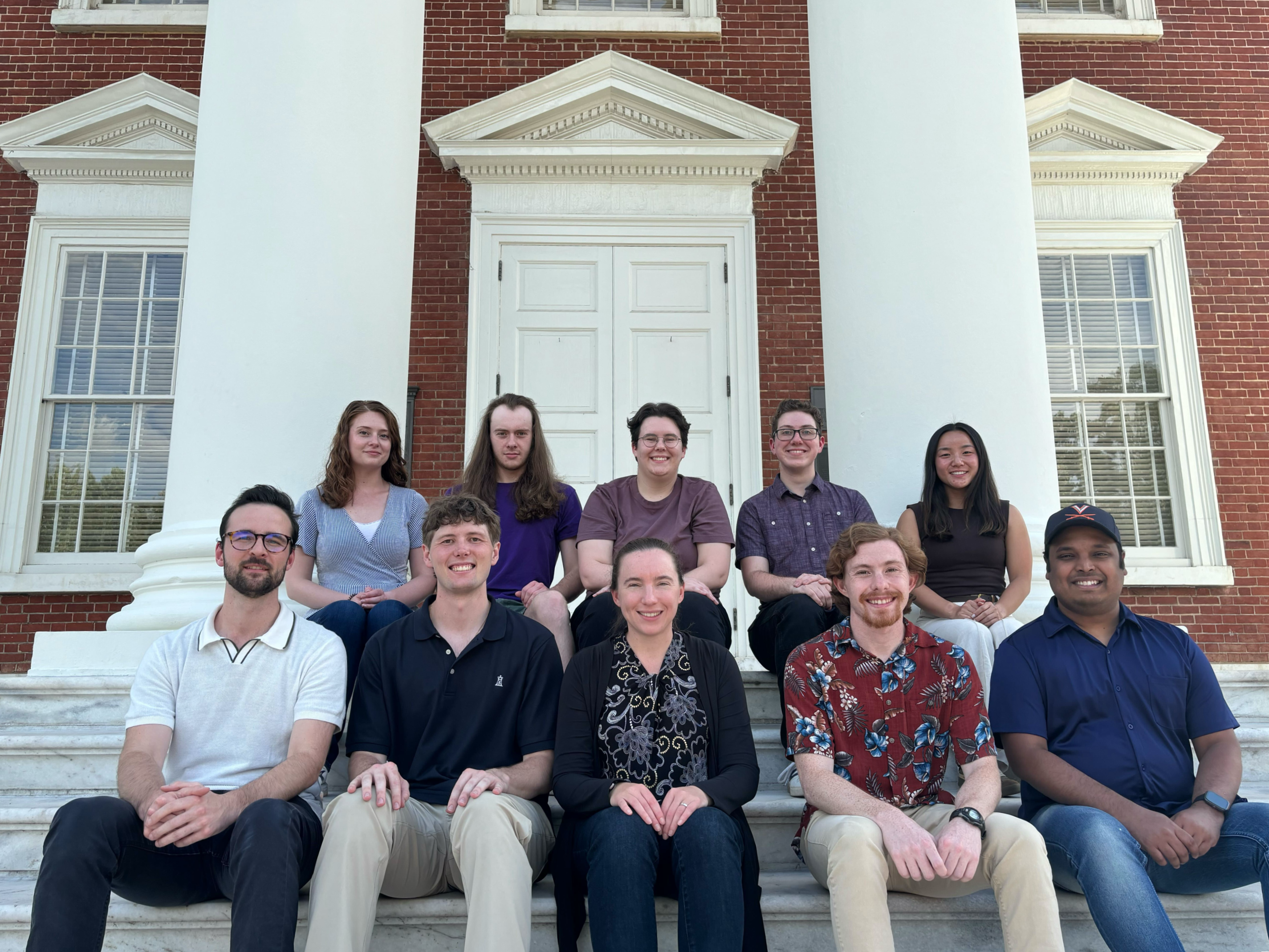 A group of people sitting on stairs outside the UVA rotunda