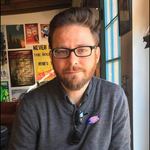 Man leaning against table