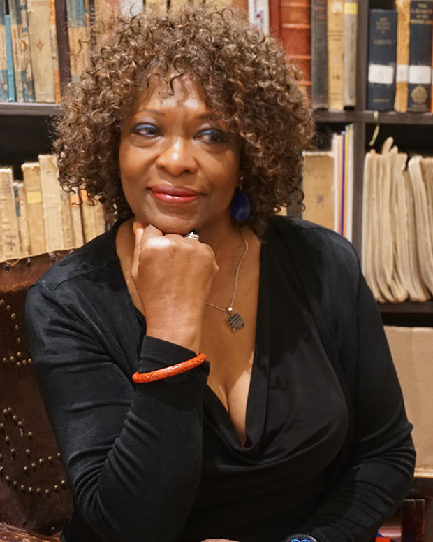 Rita Dove, looking at the camera with chin rested on right hand