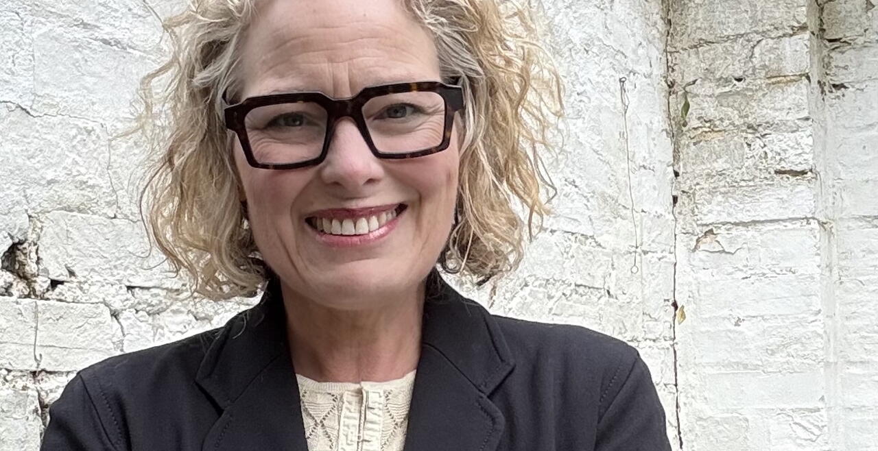 woman standing in front of a white brick wall